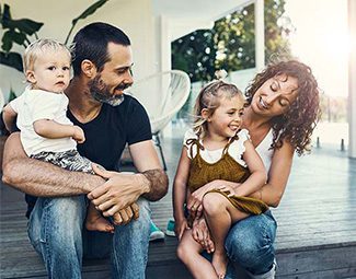 Photo of a family sitting on the porch of their home